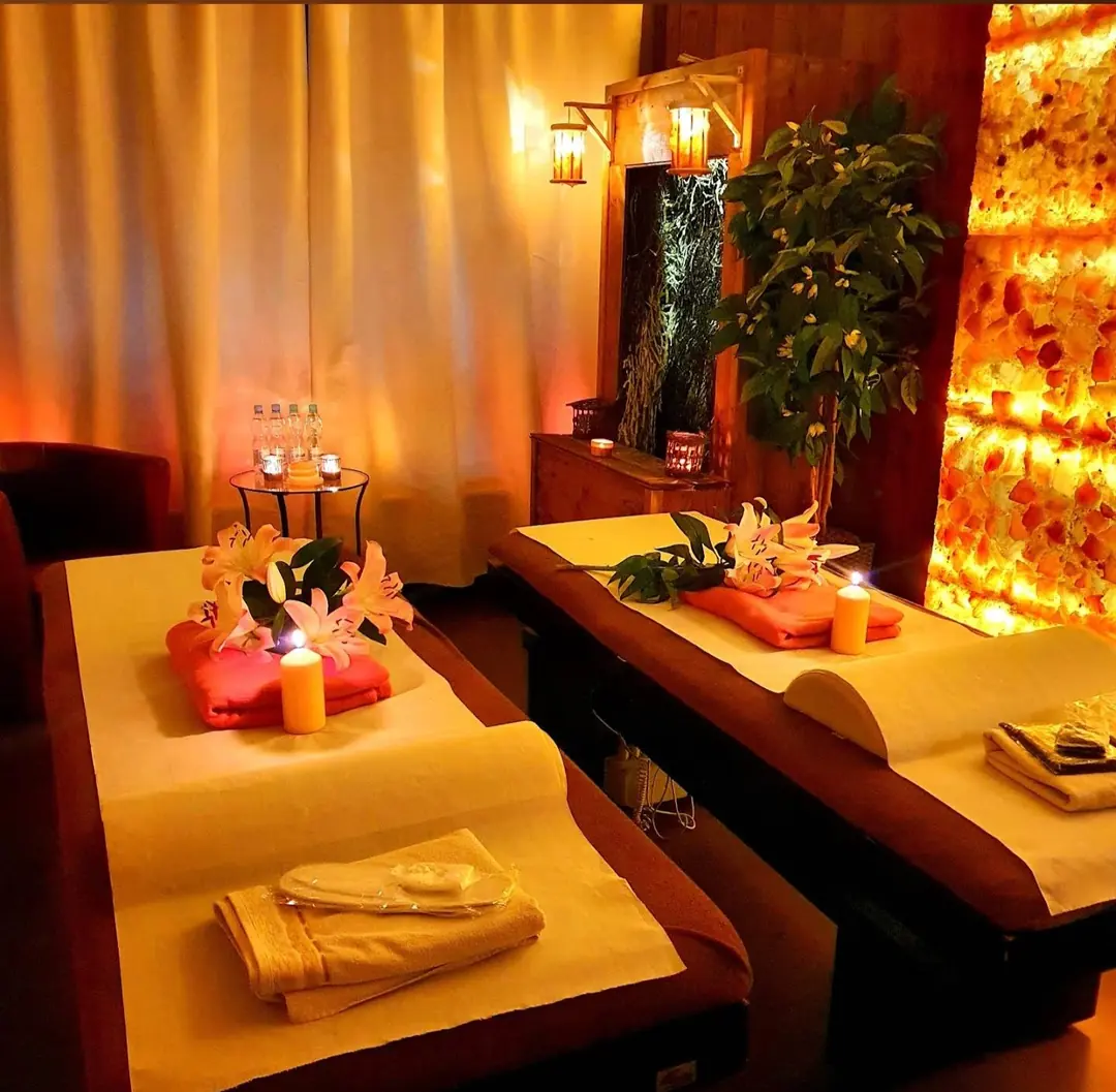 Interno del salone Świat Masażu i Relaksu – cabina con lettini da massaggio, candele e parete di sale